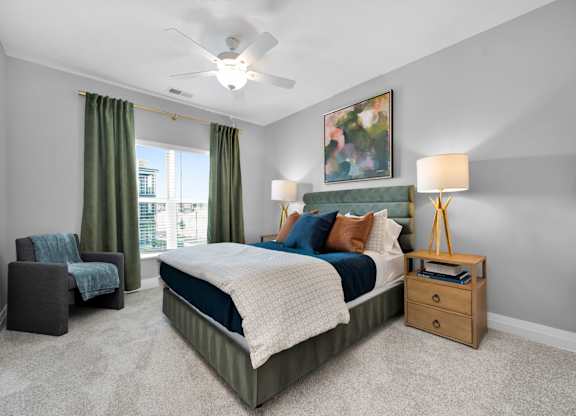 A bedroom with a bed, chair, and a painting on the wall.