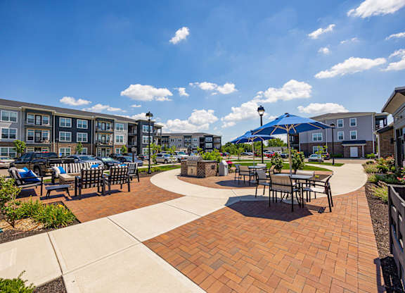A sunny day at a brick patio with tables and chairs.