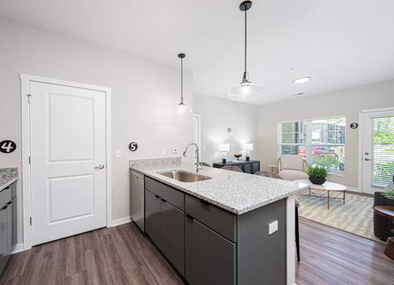 A kitchen with a white counter top and a black dishwasher.