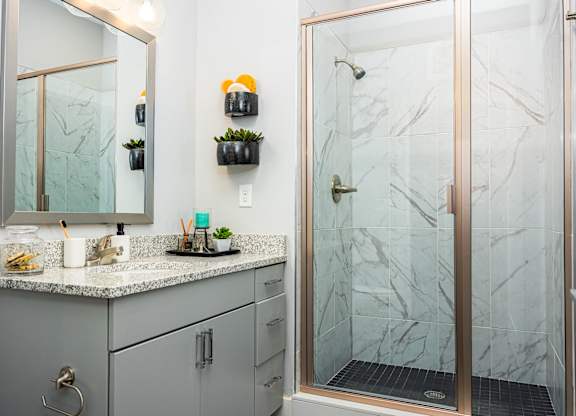a bathroom with a shower and a sink and a mirror