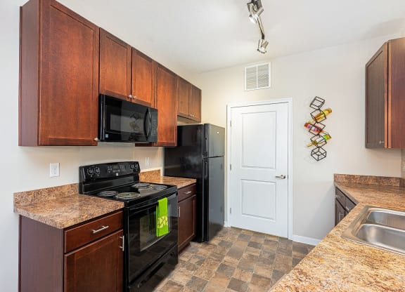 a kitchen with black appliances and granite counter tops