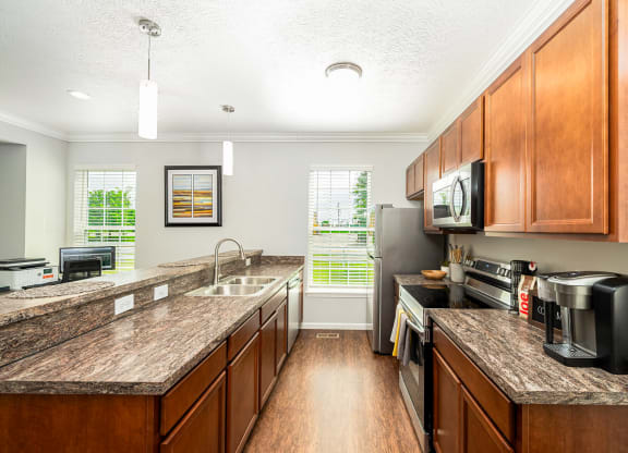 a kitchen with wooden cabinets and granite counter tops