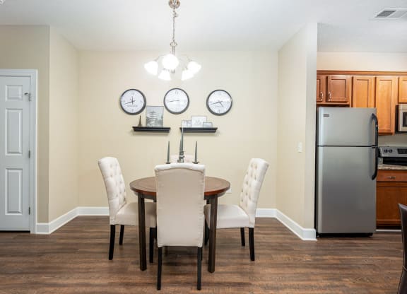 a dining room with a table and chairs and a refrigerator