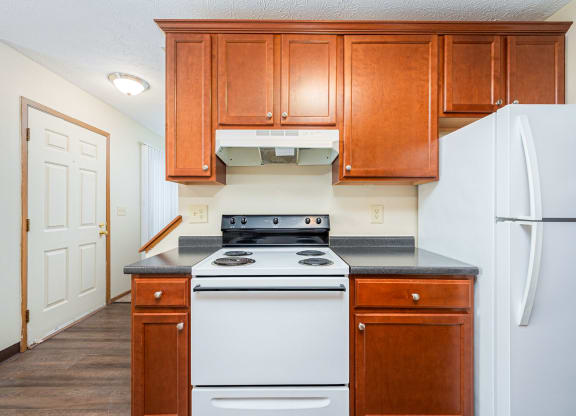 a kitchen with white appliances and wooden cabinets