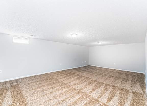A room with a carpeted floor and white walls.
