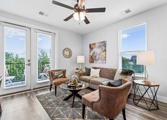 A living room with a brown chair and a brown couch.