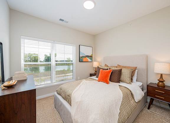 A bedroom with a large bed and a painting on the wall.