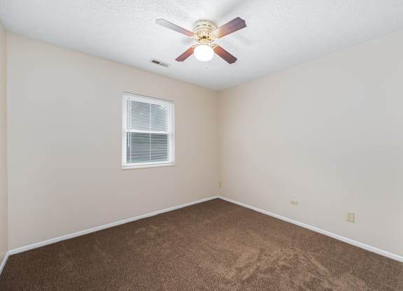 a bedroom with carpet and a ceiling fan