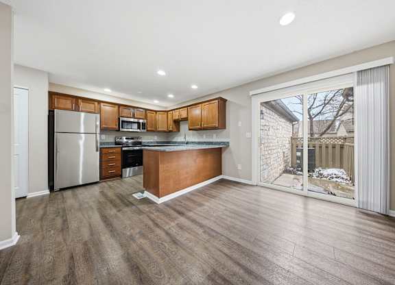 A kitchen with wooden cabinets and a refrigerator.