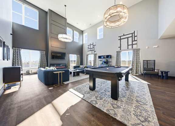 A modern living room with a pool table and a television.