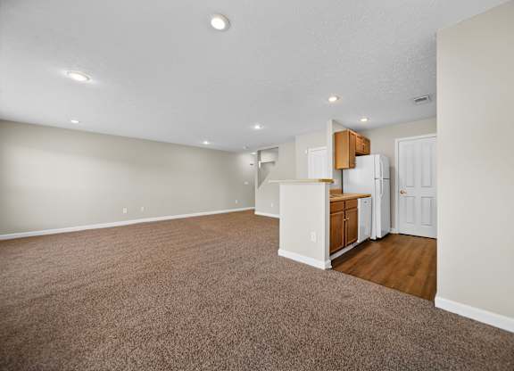 A room with a carpeted floor and a white door.