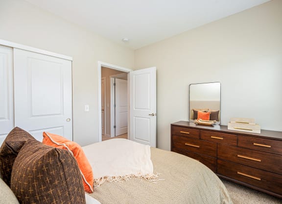 a bedroom with a bed and dresser with a mirror