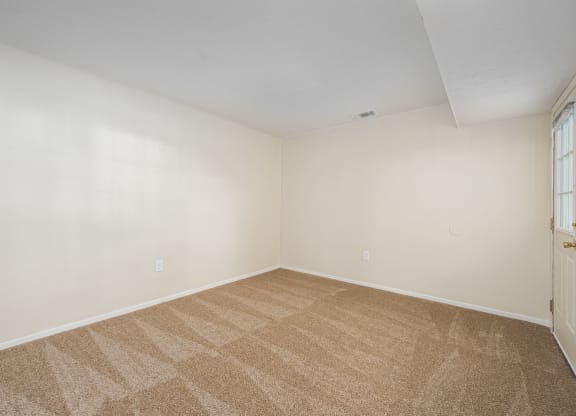 an empty room with carpet and a door