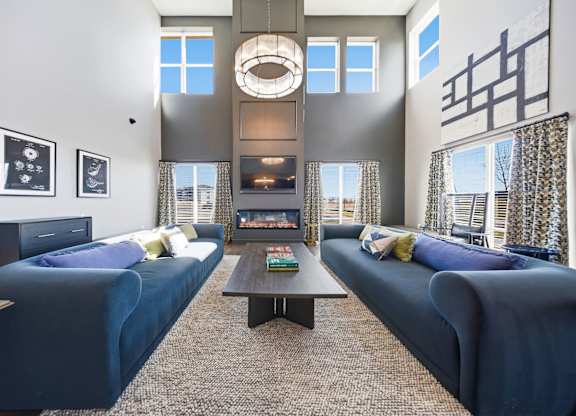 A living room with two blue couches and a coffee table.