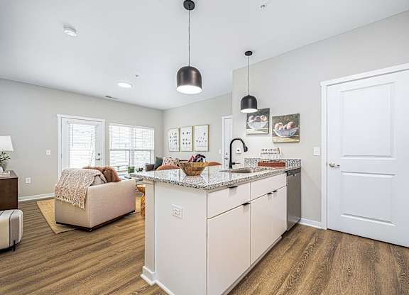 A modern kitchen with white cabinets and a central island.