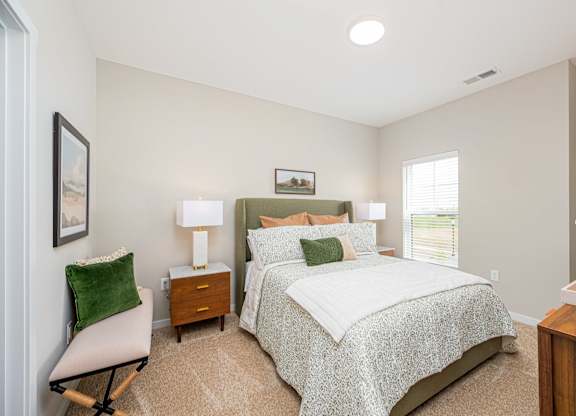 A bedroom with a large bed and a chair.