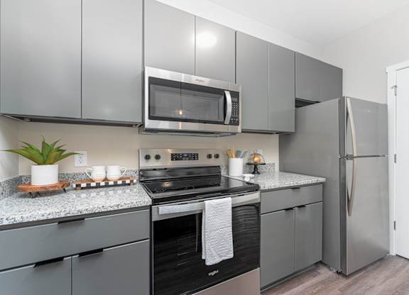 A modern kitchen with a black oven and a black and white towel hanging on the oven door.
