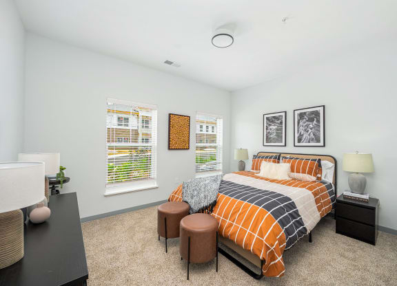 a bedroom with a bed and two windows