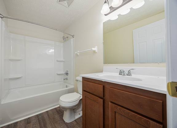 A white toilet sits next to a white sink in a bathroom.