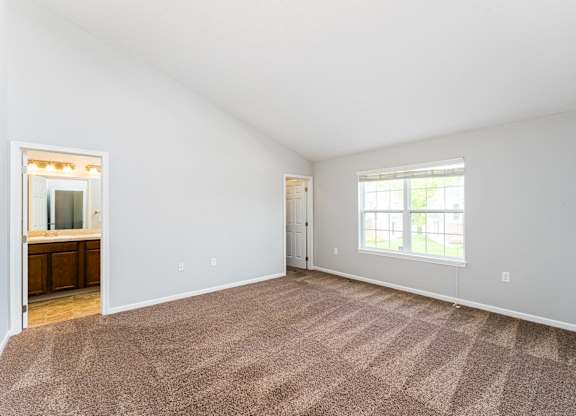 A room with a carpeted floor and a window.