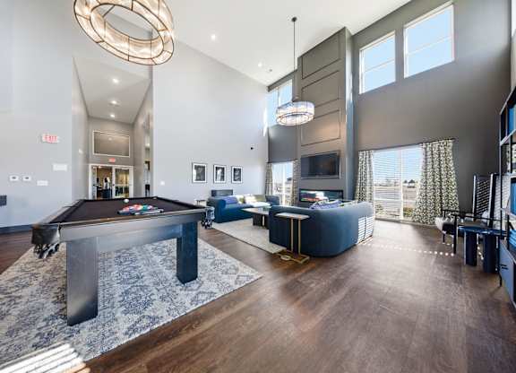 A large room with a pool table and a television.