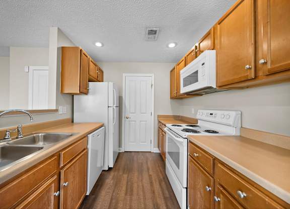 A kitchen with wooden cabinets and white appliances.
