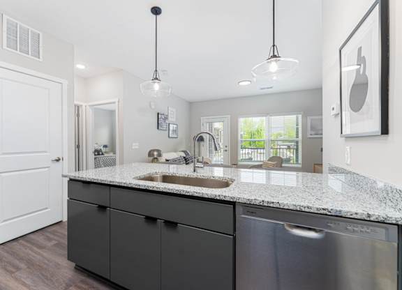 A modern kitchen with a white door and a granite countertop.