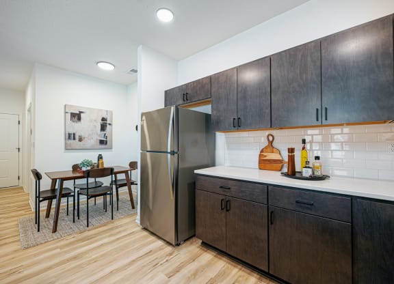 a kitchen with wooden cabinets and a stainless steel refrigerator