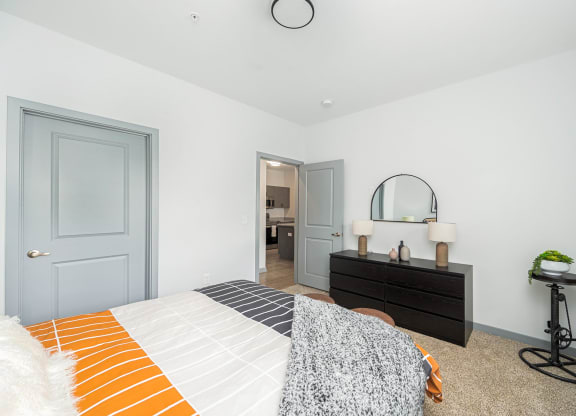 a bedroom with a bed and a dresser with a mirror