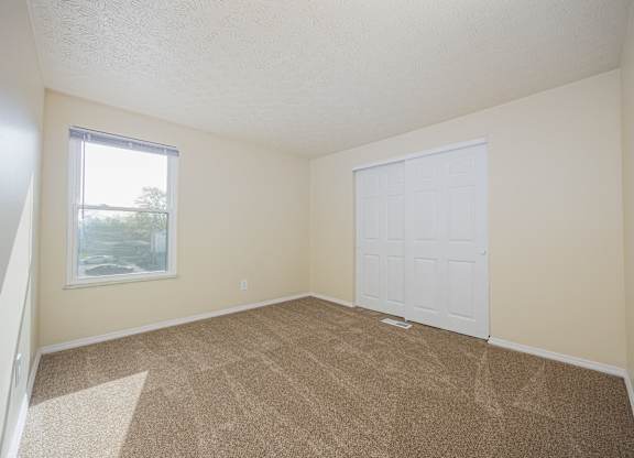 A room with a white door and carpeted floor.