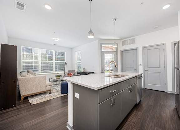 A modern kitchen with a large island and stainless steel appliances.