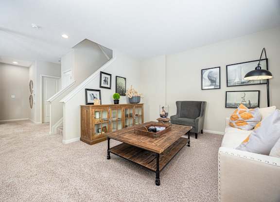 A living room with a couch, coffee table, and pictures on the wall.
