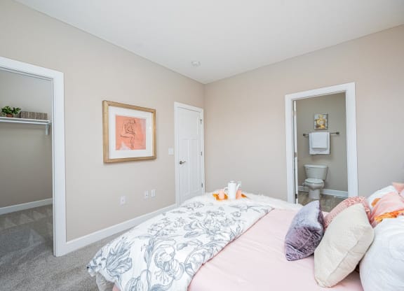 a bedroom with a bed and a door to a bathroom