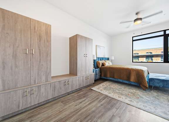 A bedroom with a bed, a dresser, and a window.