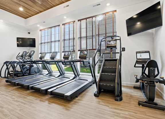 A gym with treadmills, elliptical machines, and a stair climber.