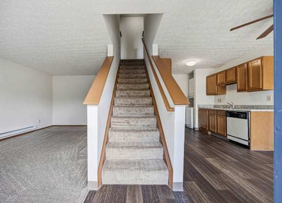 A staircase with a carpeted runner leads up to a second floor.
