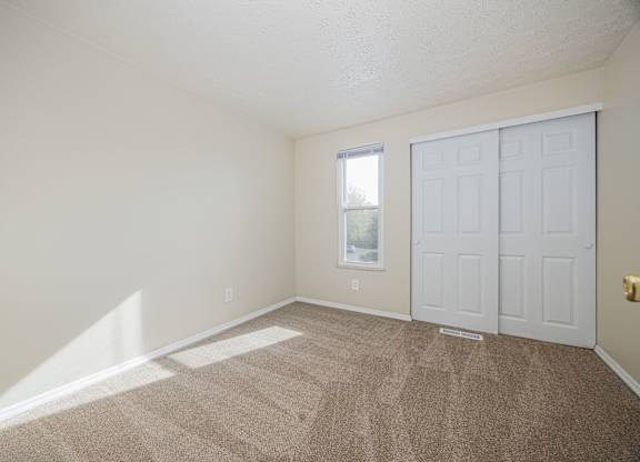 A room with a carpeted floor and a white door.