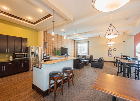 a kitchen with a bar and a living room with a table and chairs