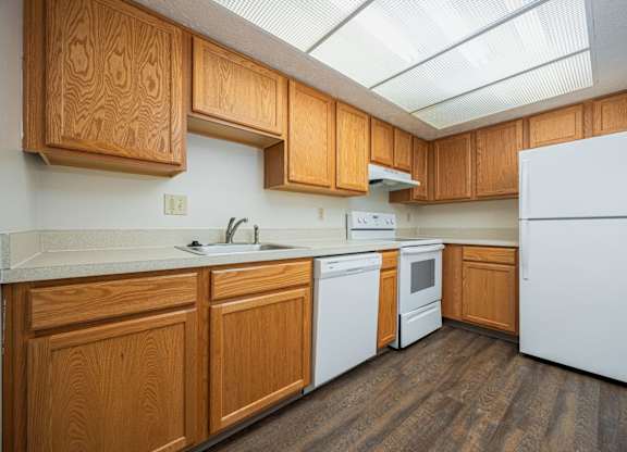 A kitchen with wooden cabinets and a white refrigerator.