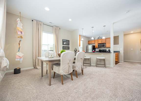 A kitchen with a dining table and chairs in the middle of the room.