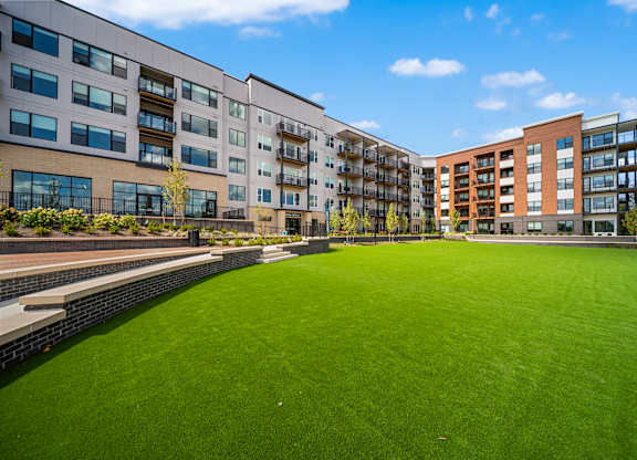 A grassy area in front of apartment buildings.