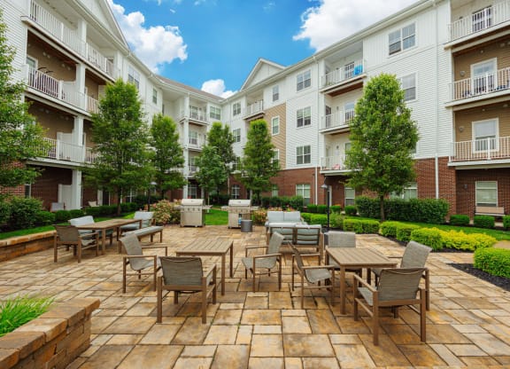 an outdoor patio with tables and chairs at an apartment complex