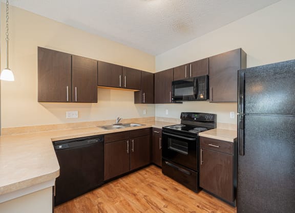a kitchen with black appliances and wooden cabinets