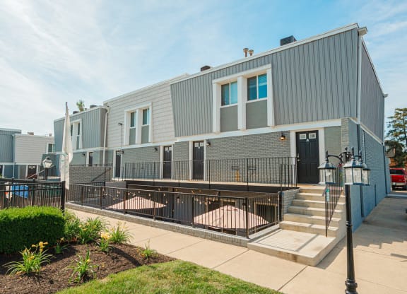 the exterior of an apartment building with stairs and a sidewalk