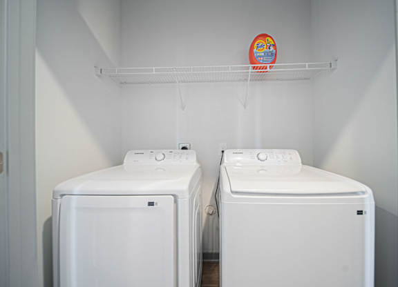 Two white washing machines in a laundry room.
