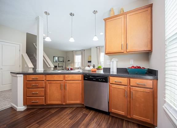 A kitchen with wooden cabinets and a black countertop.