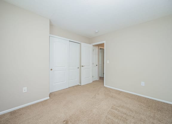 a bedroom with two closets and a door to a hallway