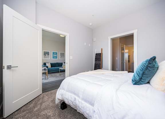 a bedroom with a white bed and a closet