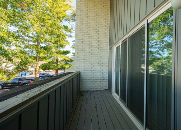 a balcony with a view of the street and trees