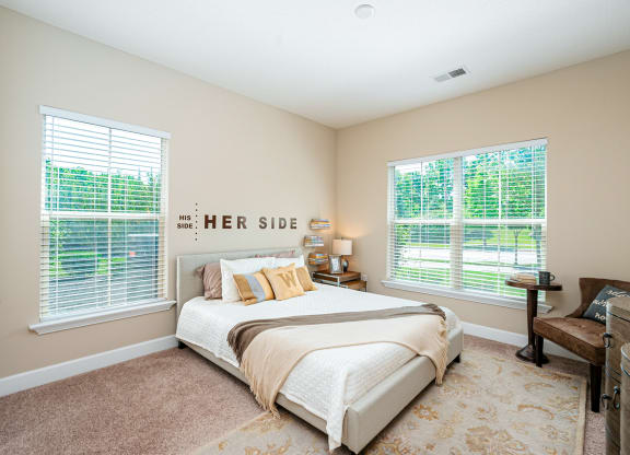 a bedroom with a bed and two windows
